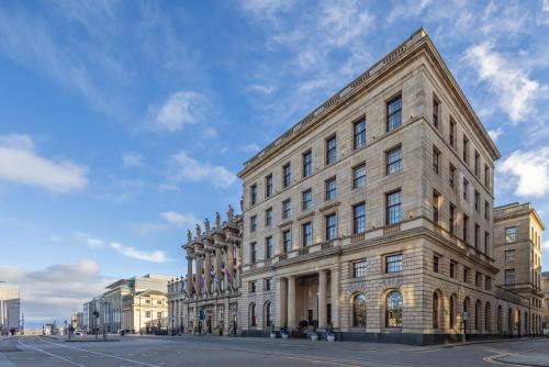 a large stone building on a city street at The Edinburgh Grand, a Luxury Collection Hotel, Edinburgh in Edinburgh