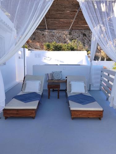 a room with three beds and a table at Filia Bungalow in Archangelos