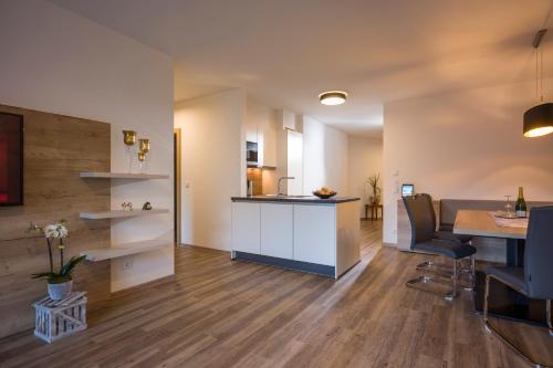 a kitchen and living room with a table and chairs at Aparthotel AlpTirol in Kaltenbach