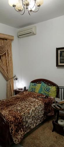 a bedroom with a bed and a chandelier at Chambre single de Luxe in Kasbah