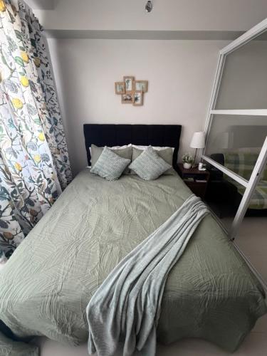 ein Schlafzimmer mit einem großen Bett in einem Zimmer in der Unterkunft Ana condo at Primeworld District in Agus