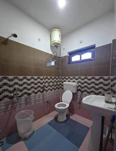 a bathroom with a toilet and a sink at Adventure valley Rajgundha in Kangra