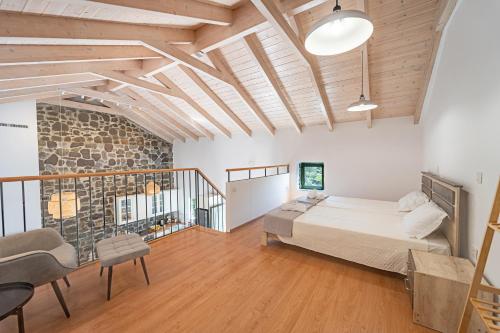 a bedroom with a bed and a stone wall at Twin Olive Villas in RhodesRhodes
