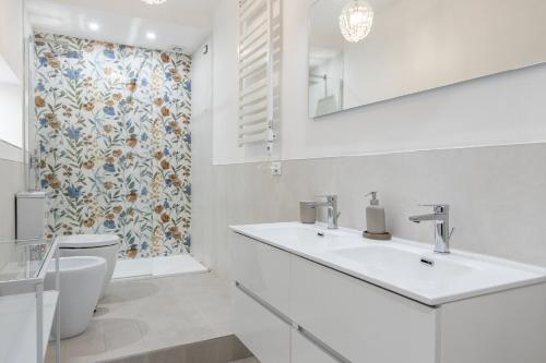 a white bathroom with a sink and a toilet at GuestHost - Chic Central Apartment in Montecatini in Montecatini Terme