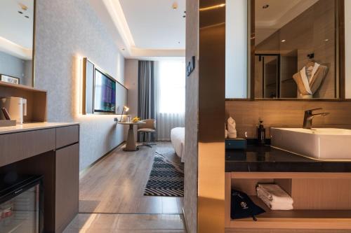 a hotel bathroom with a sink and a tub at JOY Hotel Hangzhou in Hangzhou