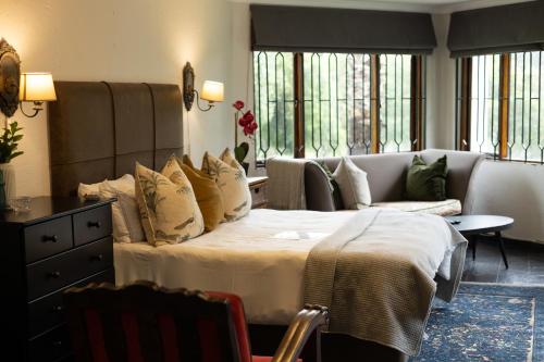 a hotel room with a bed and a couch at The River Cottage in Muldersdrift