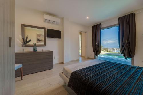 a bedroom with a large bed and a large window at Luxury Liam Villa with Pool and Sea View - Goelba in Portoferraio
