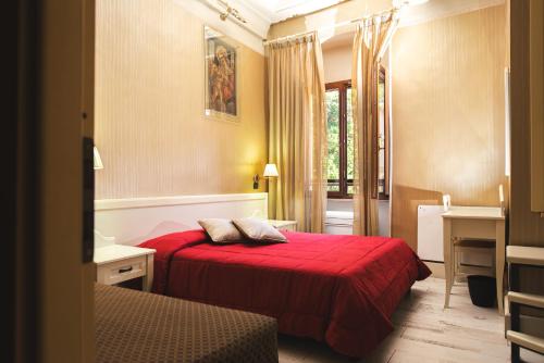 a hotel room with a red bed and a bathroom at Palazzo Riario in Viterbo