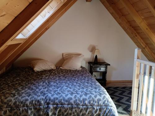 a bedroom with a bed in a attic with a window at Chalet lac Celinda in Saint-Mamet