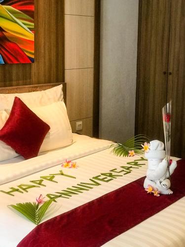 a hotel room with a bed with a stuffed animal on it at The Kirana Canggu Hotel in Canggu