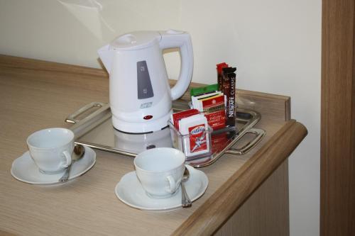 a coffee maker and two cups on a counter at Domus Australia in Rome