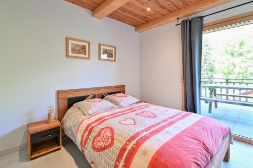a bedroom with a bed and a large window at Appartement Alice - Dans chalet in Les Villards-sur-Thônes
