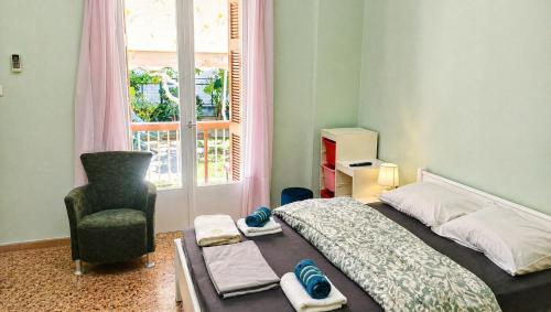 a bedroom with a bed and a chair and a window at Konstantinou Apartments in Paralio Astros