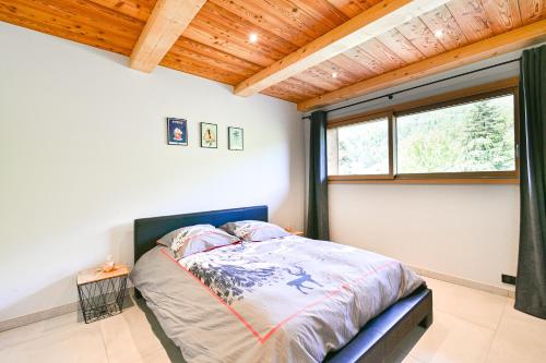 a bedroom with a bed in a room with a window at Appartement Lisa - Dans chalet in Les Villards-sur-Thônes