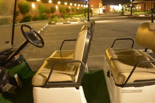 a golf cart with empty seats on a street at Aquamarine Kuwait Resort(Families Only) in Al Nuwaiseeb