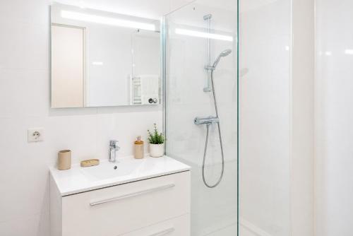 a white bathroom with a shower and a sink at Appartement Terrasse St Florent in Saint-Florent