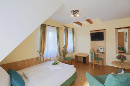 a hotel room with a bed and a desk at Landhotel Villa Moritz garni in Oberahr