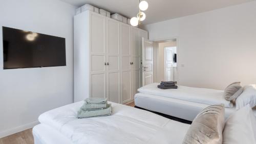 a living room with two beds and a flat screen tv at Sali Homes - Opera Loge 2BR Balcony in Bayreuth