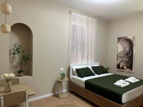 a bedroom with a bed with green sheets and a window at Affittacamere Yara 5 Terre in La Spezia