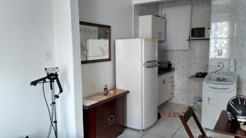 a kitchen with a refrigerator and a table and a tripod at Kitinet na Praia de Botafogo in Rio de Janeiro