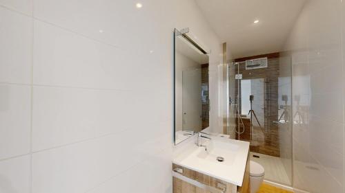 a white bathroom with a sink and a mirror at Apto Panoramic in L'Ampolla
