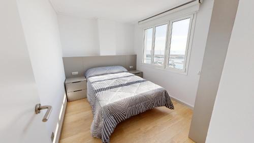 a small bedroom with a bed and a window at Apto Panoramic in L'Ampolla