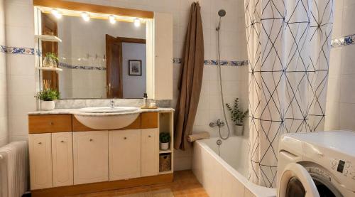 a bathroom with a sink and a tub and a mirror at Chalet con jardin cerca de la playa in Can Pastilla