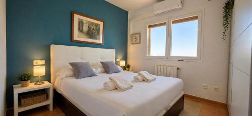 a bedroom with a large white bed with a window at Chalet con jardin cerca de la playa in Can Pastilla