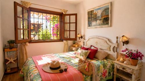 a bedroom with a bed with a hat on it at Casa Blanca 42 – Piscina, BBQ y Wifi (5 pax) in Tossa de Mar