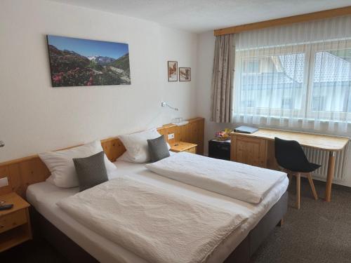 a hotel room with a bed and a desk at Grünwaldhof in Tux