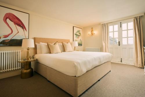 a bedroom with a large white bed and a window at The Godolphin Hotel in Marazion