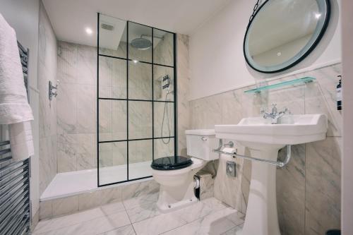 a bathroom with a toilet and a sink and a mirror at The Godolphin Hotel in Marazion