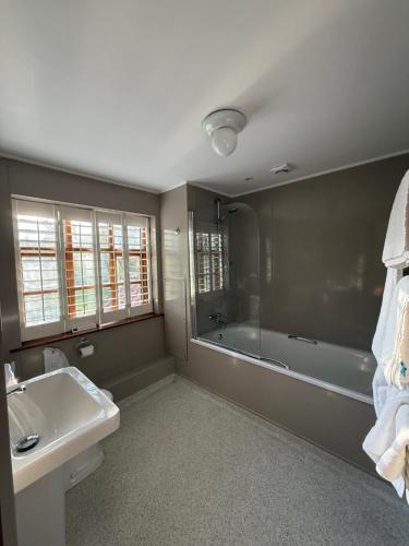 a bathroom with a bath tub and a sink and a bath tub at Ivy House Country Hotel in Lowestoft