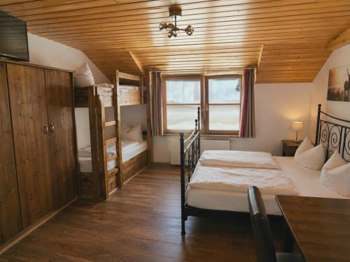 a bedroom with two bunk beds and a table at Hotel Karwendelblick in Urfeld