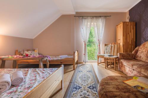 a bedroom with a bed and a couch and a table at Zameczek in Mikołajki