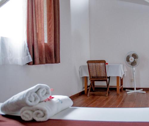 a room with a table with a chair and a towel at Hotel Océan Beach Sakatia in Nosy Be