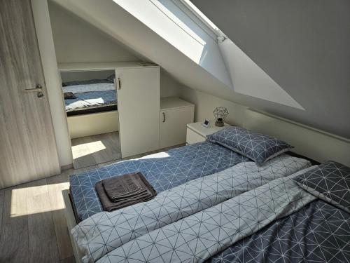 a attic bedroom with a bed and a window at Apartment Ledince in Most na Soči