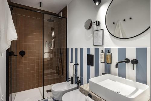 a bathroom with a sink and a toilet and a mirror at Valesmeralda Boutique Rooms, Porto Cervo Marina Adults only in Porto Cervo