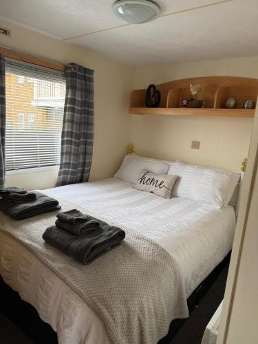 a bedroom with a bed with towels on it at my happy place caravan in Trusthorpe