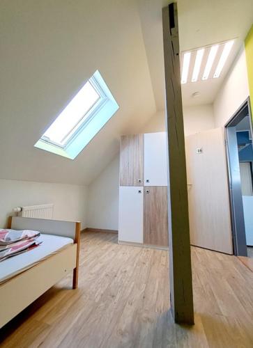a attic room with a bed and a skylight at Schullandheim Bautzen Burk nahe der Talsperre - Dachkammer deluxe in Bautzen