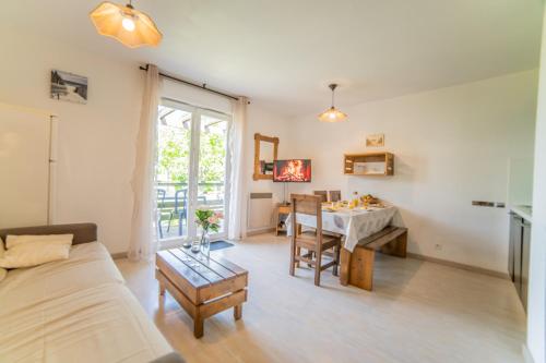 a living room with a couch and a table at Le Bellevue, 50m lac, piscine, parking, wifi, baignade surveillée in Aureilhan