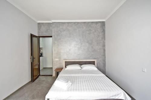 a bedroom with a white bed and a mirror at Sirik hotel in Zvartnots International Airport
