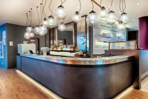 a bar in a restaurant with lights above it at Premier Inn Stuttgart Bad Cannstatt in Stuttgart