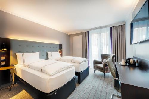 a hotel room with two beds and a desk at Premier Inn Stuttgart Bad Cannstatt in Stuttgart