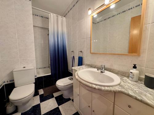 a white bathroom with a toilet and a sink at Marenostrum view in Playa Pobla de Farnals