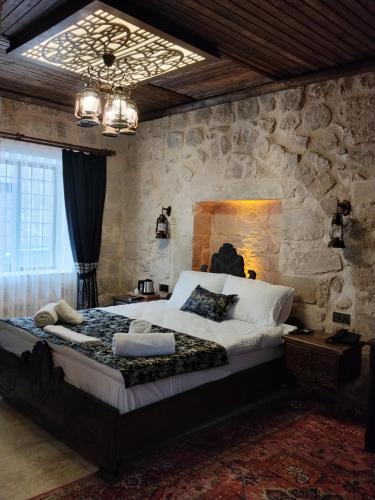 a bedroom with a large bed in a stone wall at Kasrı Hatun Konağı in Mardin