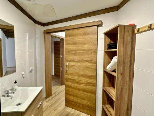 a bathroom with a wooden door and a sink at Villa El Guanche -Boutique Apartments & rooms in Gáldar