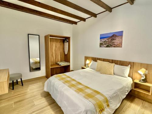 a bedroom with a large bed and a desk at Villa El Guanche -Boutique Apartments & rooms in Gáldar
