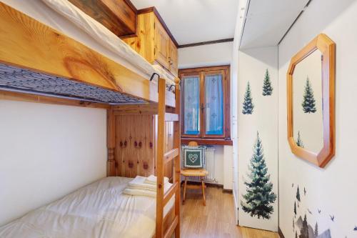 a small bedroom with a bunk bed and a chair at Casetta del Caregon a Vinigo in Vodo Cadore
