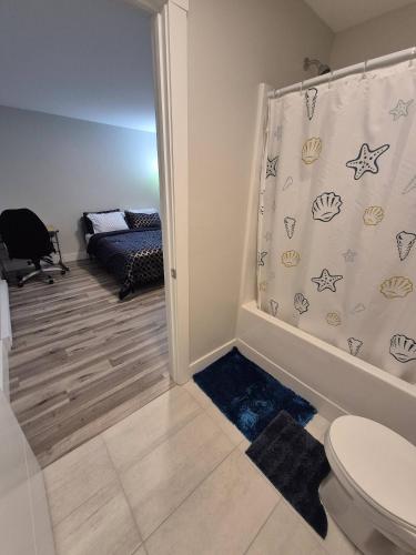 a bathroom with a toilet and a shower curtain at Cozy Newly Built Room in Halifax
